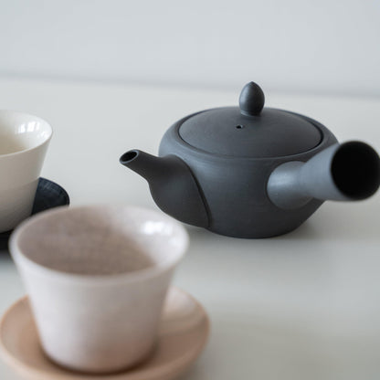 A Japanese teapot and teacups on tea saucers