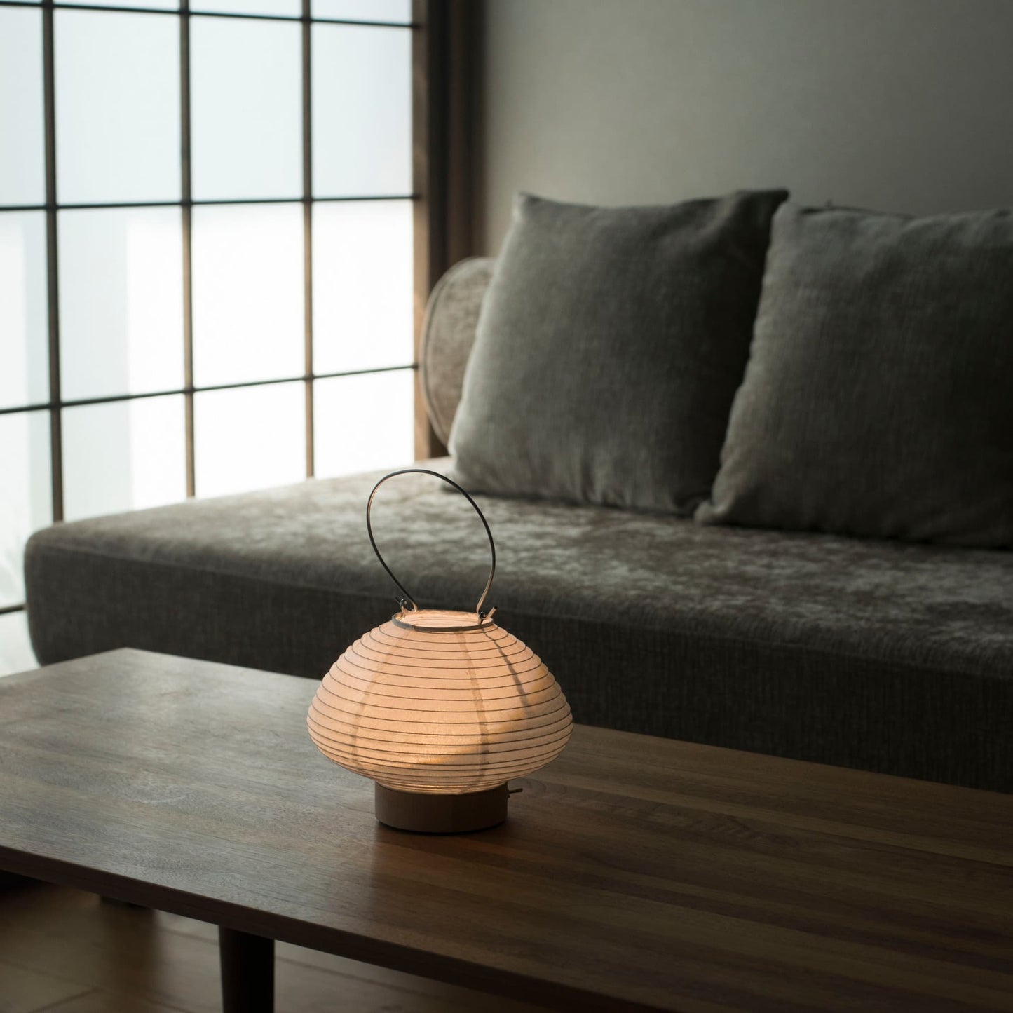 Japanese table lamp on a wooden table in a Japandi living room. 
