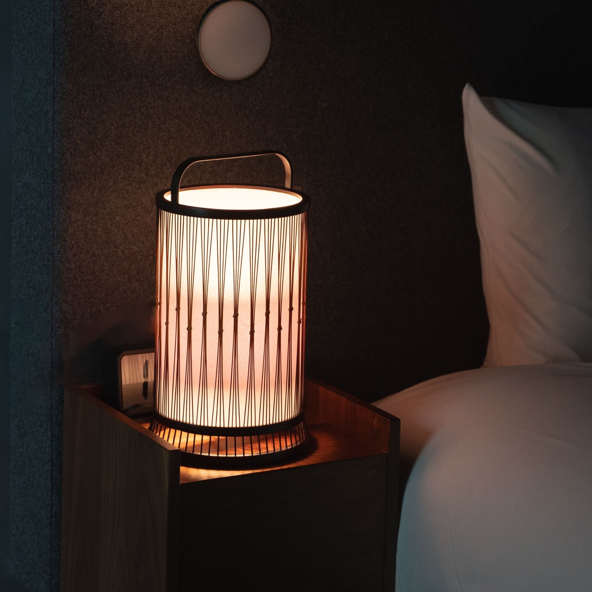 A Japanese bamboo lamp on a bedside table in Japandi bedroom