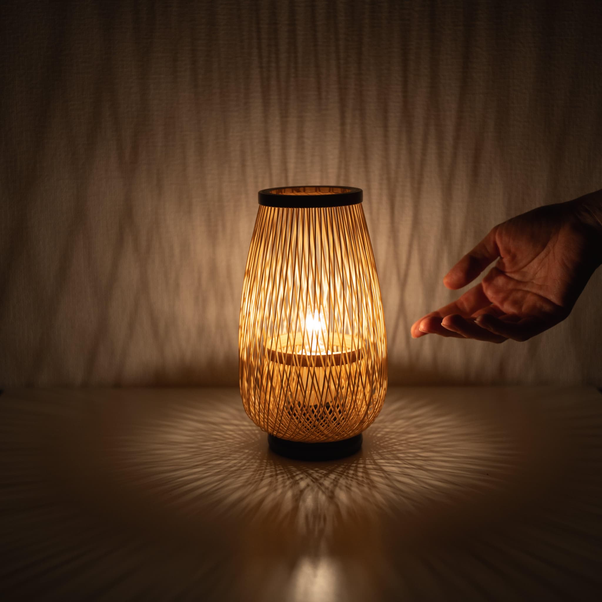 Hand holding a table lamp made with bamboo weaving techniques from Shizuoka, Japan, with 800 years of history.