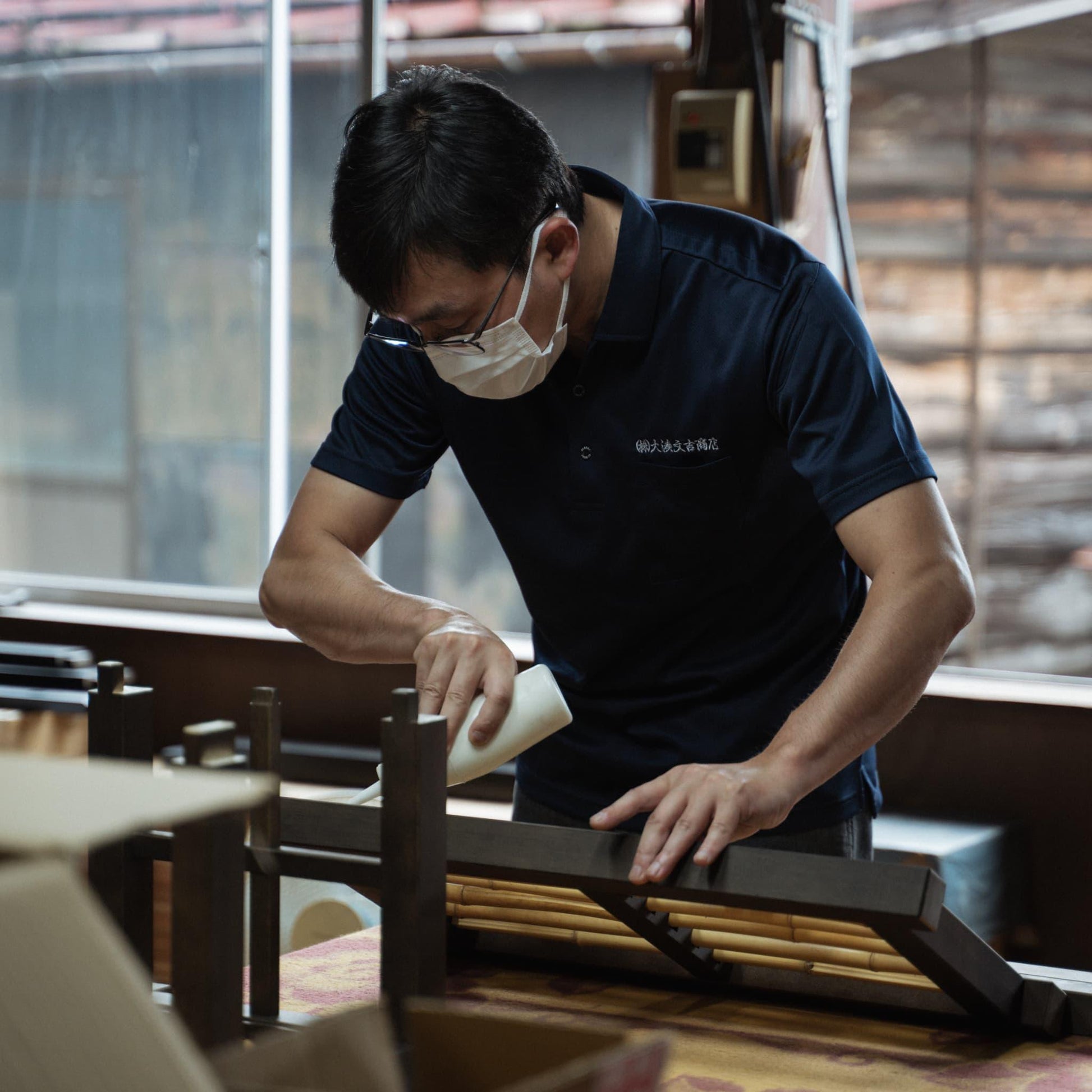 A Japanese artisan crafting bamboo interior pieces in the workshop.