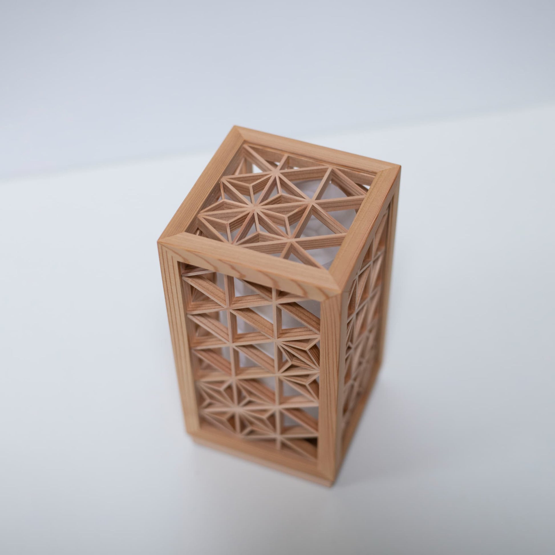 A table lamp using kumiko, a traditional Japanese technique of assembling small wooden pieces to create geometric patterns.