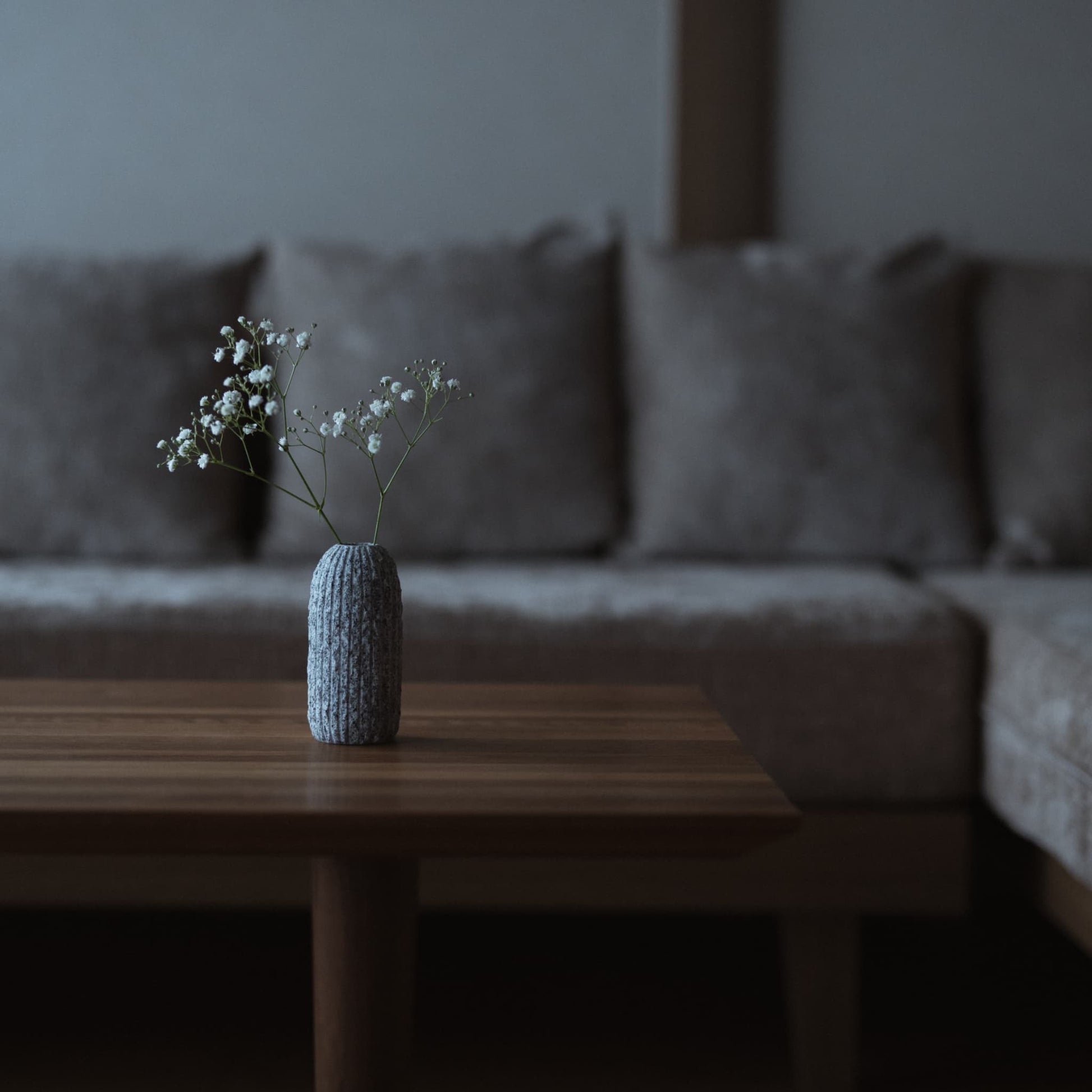 Aji stone flower vase on a table in Japandi living room. 