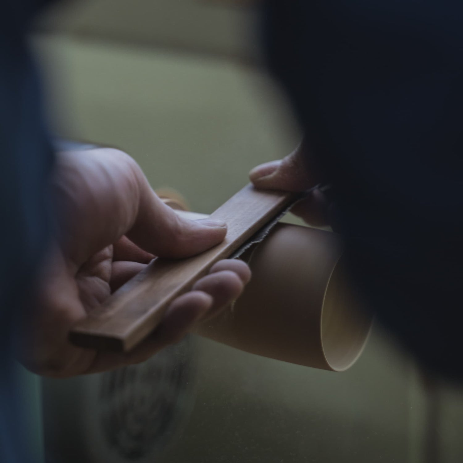 Sanding a bamboo stalk with sandpaper on a rotating machine