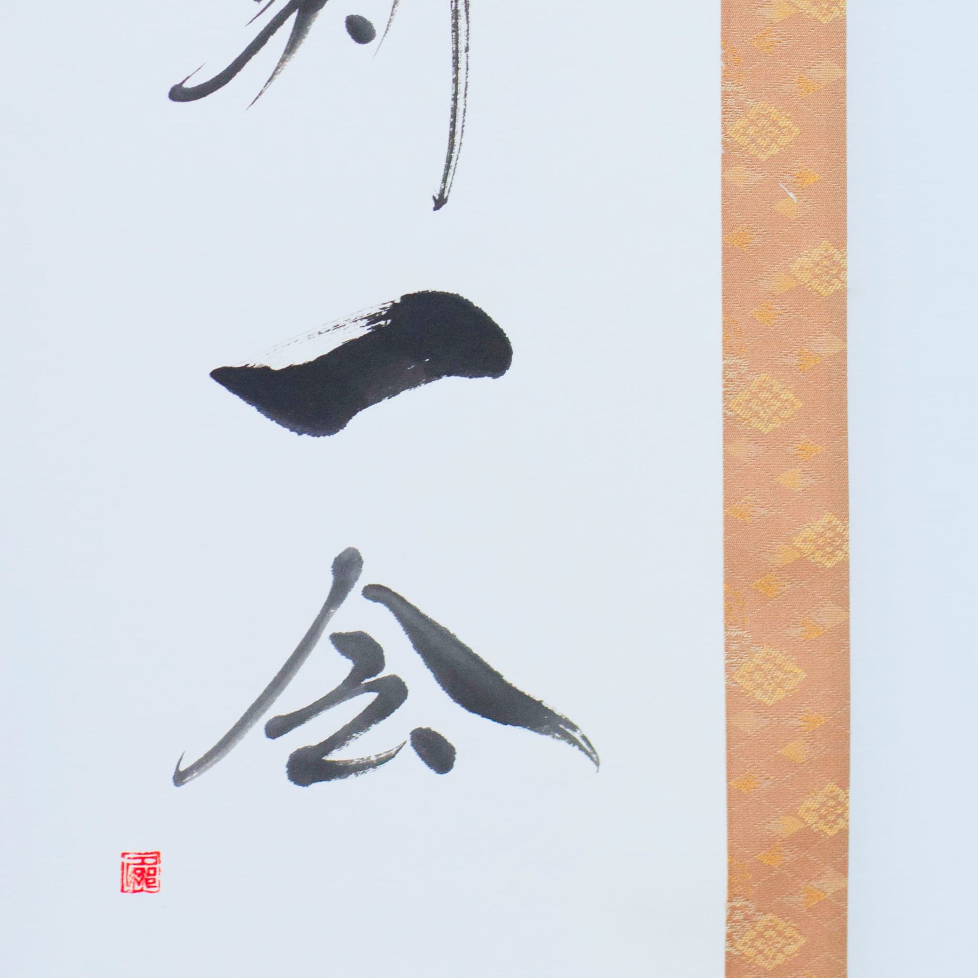 Close-up of the lower left corner of a hanging scroll, focusing on the Japanese calligraphy for '一会' (one meeting)