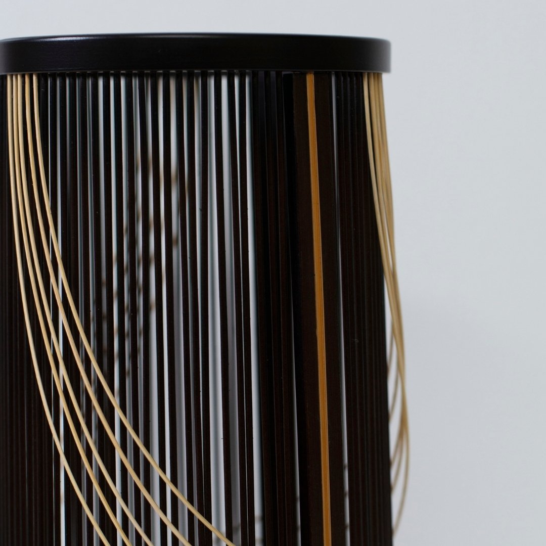 Japanese Bamboo Flower Vase 'Flowing Water'—a black bamboo vase with woven details mimicking water flow, exuding wabi-sabi charm