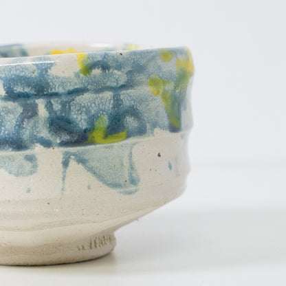 Close-up of "Splash" matcha chawan bowl with blue glaze evoking water splashes in sunlight.