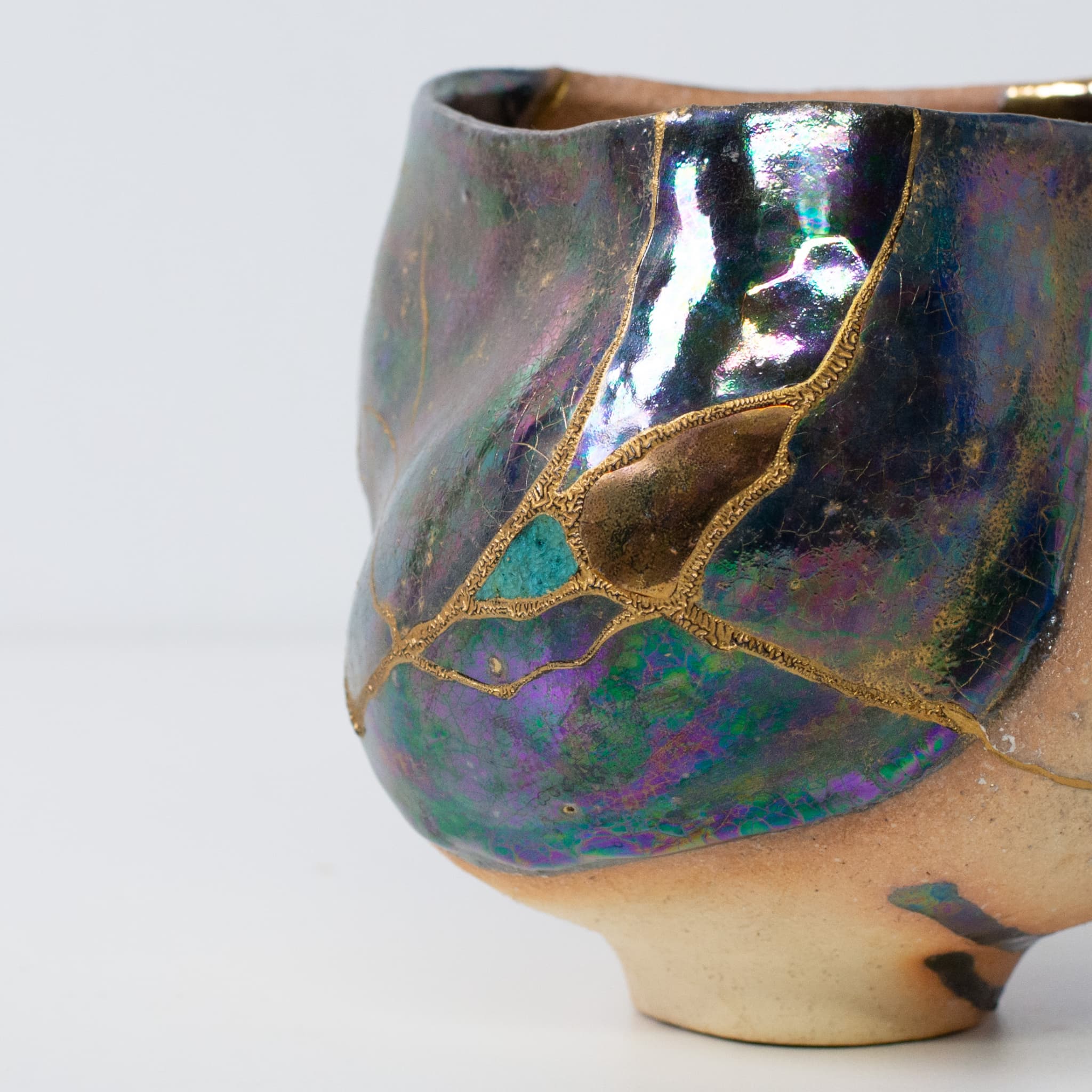 Close-up of Japanese kintsugi matcha bowl showing detailed gold lacquer repairs