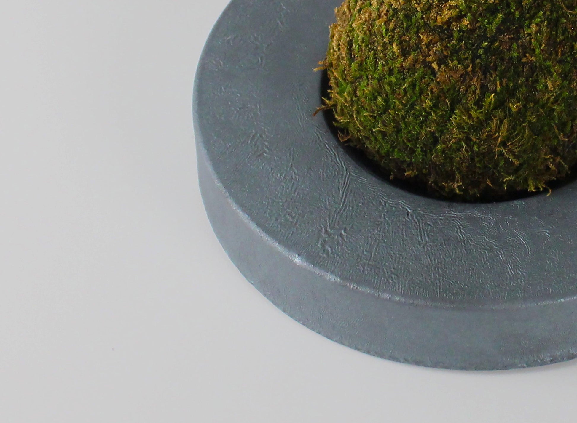 A minimalist iron bonsai pot inspired by traditional Japanese roof tiles.