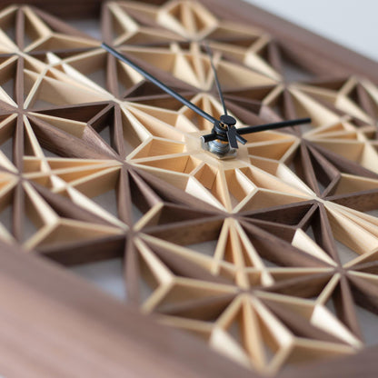 Detailed view of the intricate pattern of a walnut kumiko clock. The small wooden pieces are meticulously joined to create a stunning design.