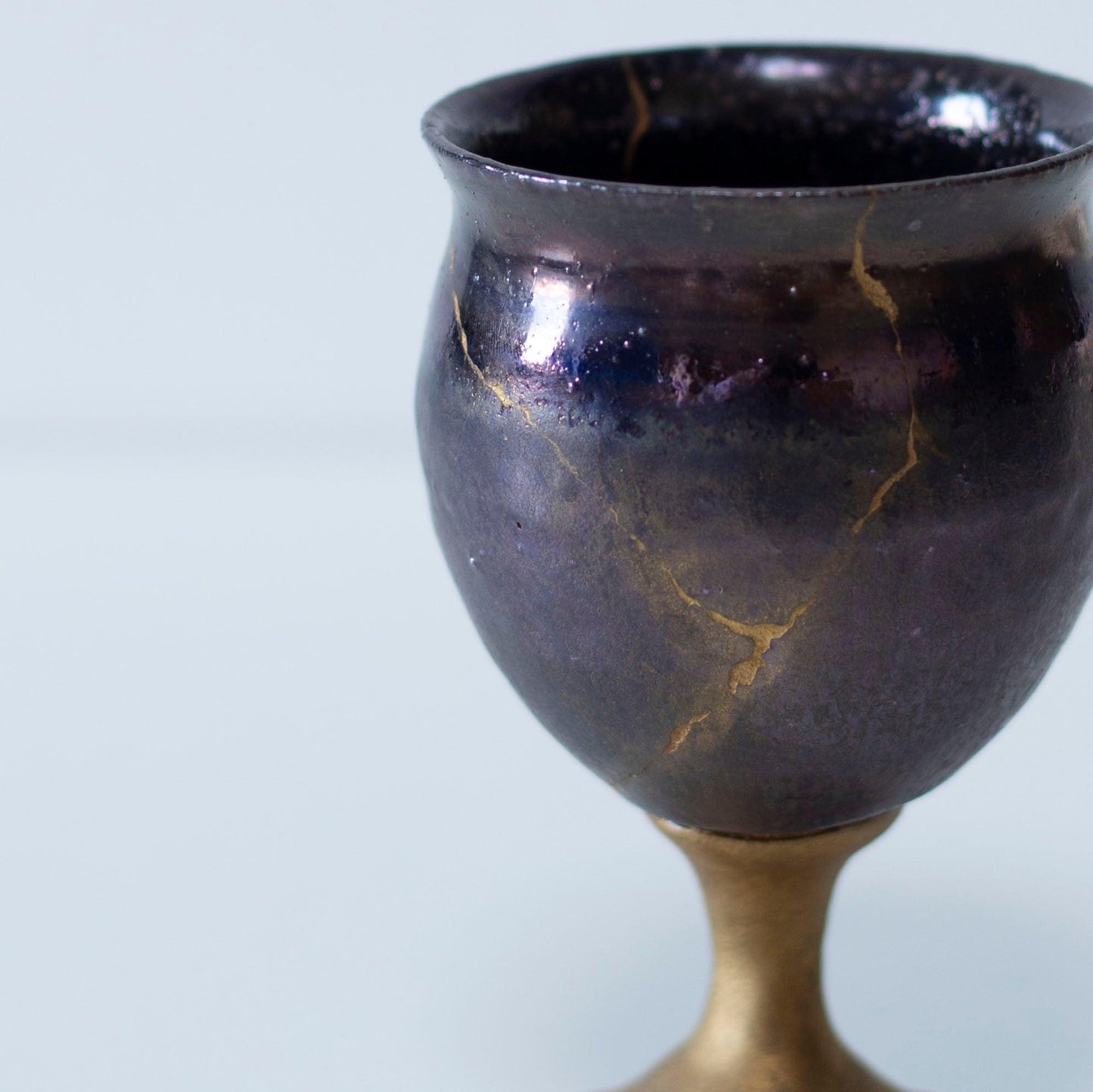 Magenta kintsugi wine goblet repaired with Kintsugi, a traditional Japanese technique.