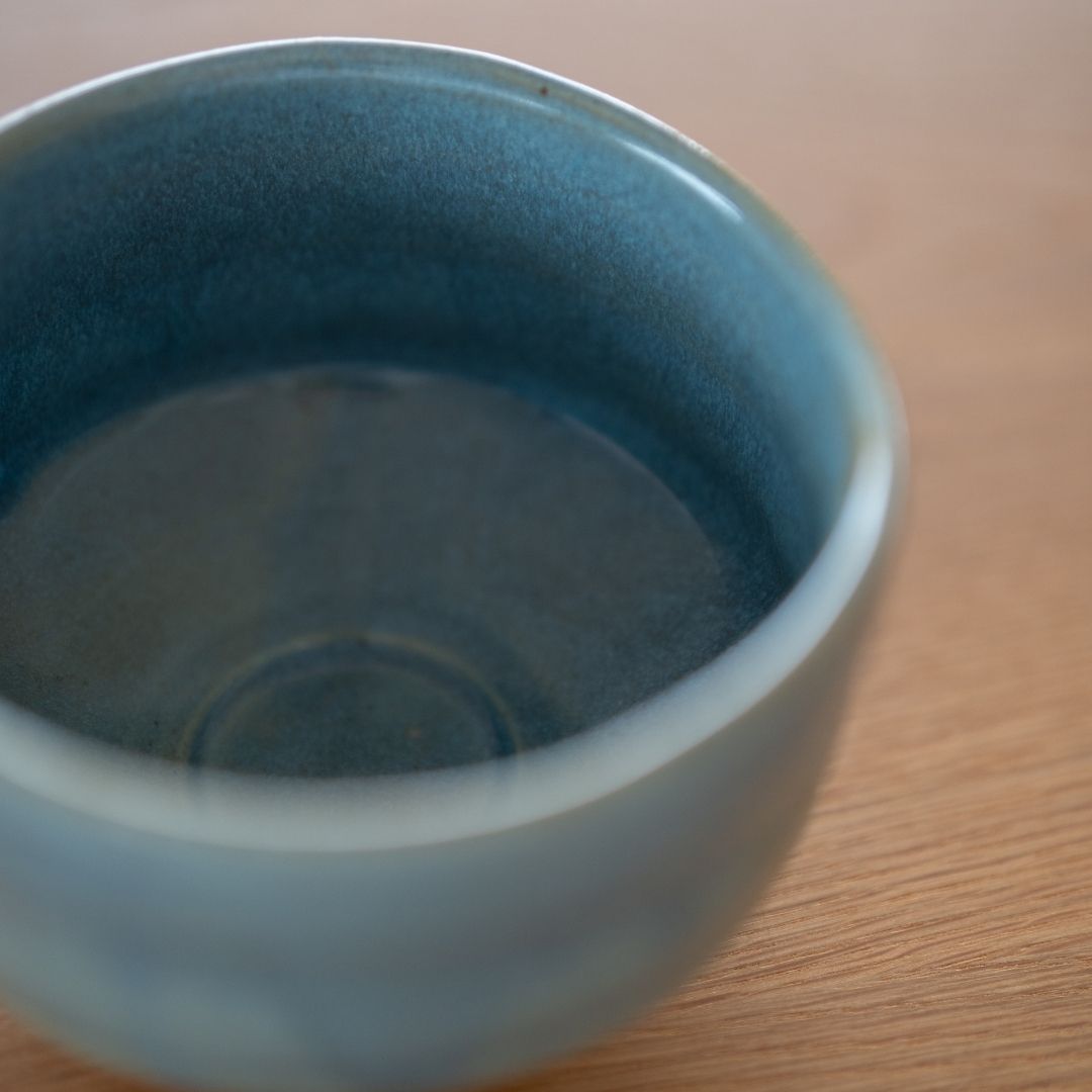 Angled top-down view of the "Summer Sky" deep blue Japanese matcha bowl interior, showing the bowl's depth, smooth center, and the subtle variations of the blue glaze.