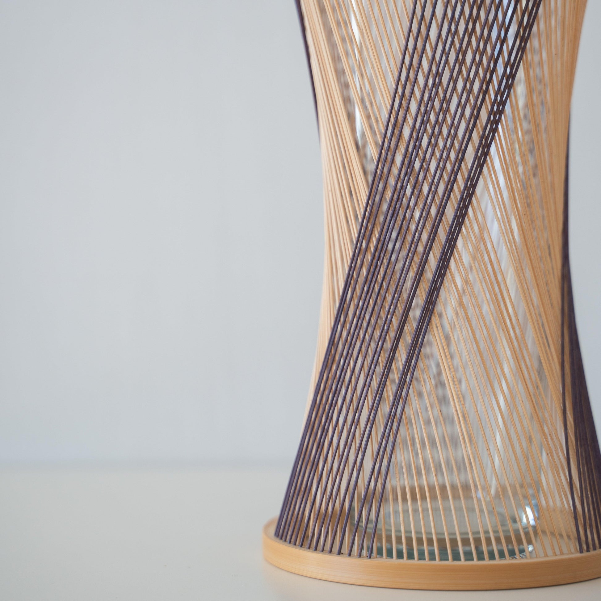 Detail of handcrafted Japanese bamboo vase, meticulously crafted by skilled artisans using traditional bamboo weaving techniques, showcasing the natural beauty and elegance of bamboo.