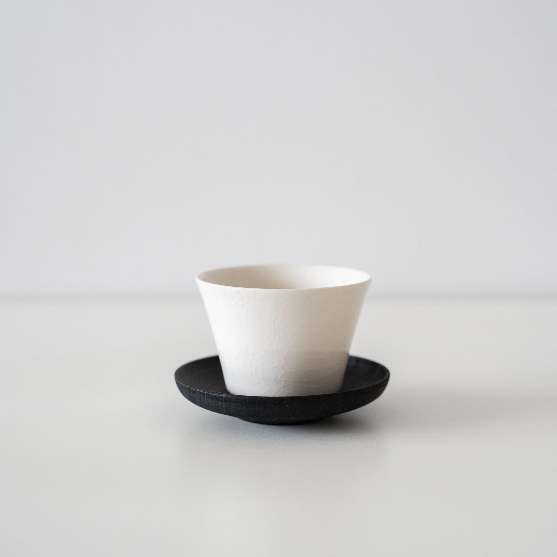 A delicate white Banko ware teacup with beautiful crackle glaze, embodying the concept of wabi-sabi.