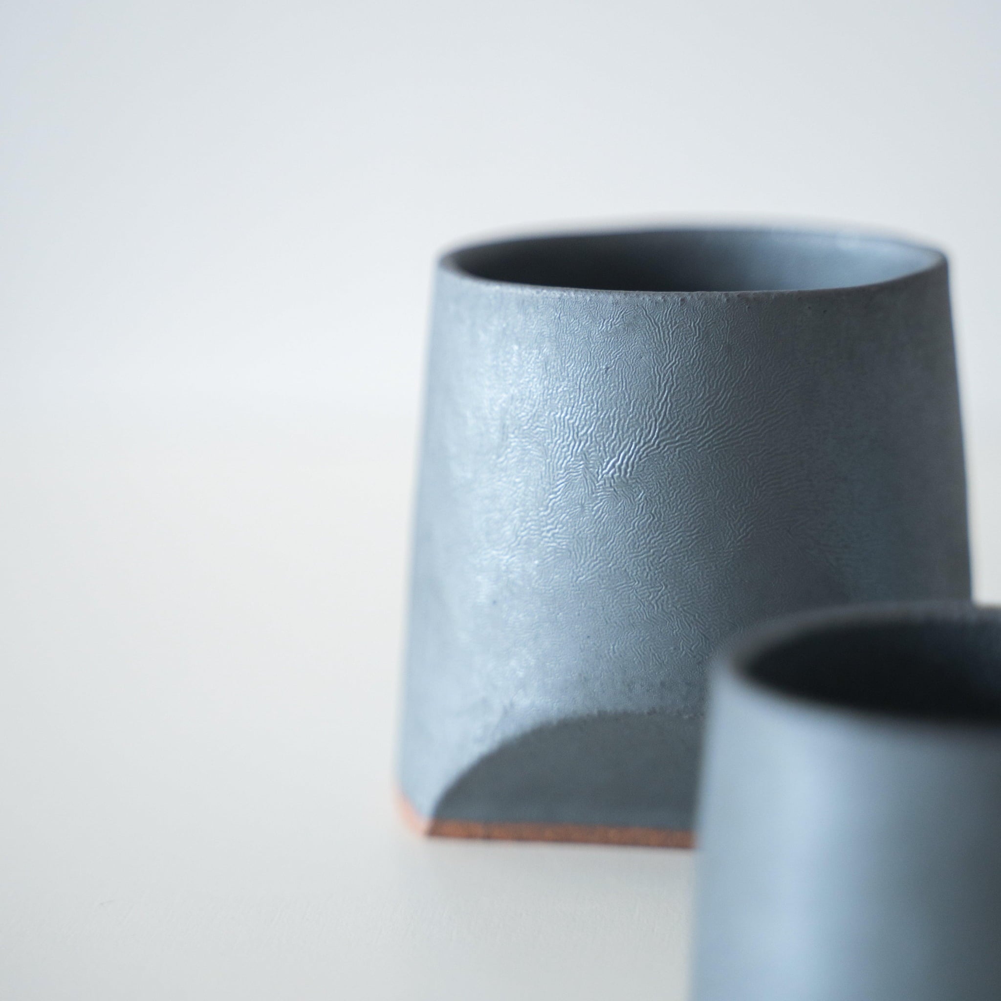 Iron-colored sake cup, crafted using traditional Japanese roof tile techniques.