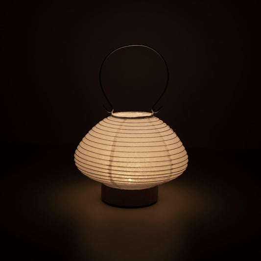 Hand holding a portable table lamp resembling a traditional Japanese lantern, crafted with Gifu lantern techniques and Mino washi paper.