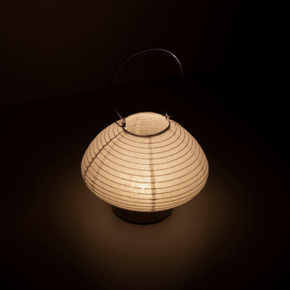 Detail of a portable table lamp crafted with Gifu lantern techniques and Mino washi paper, emitting a soft, warm light.