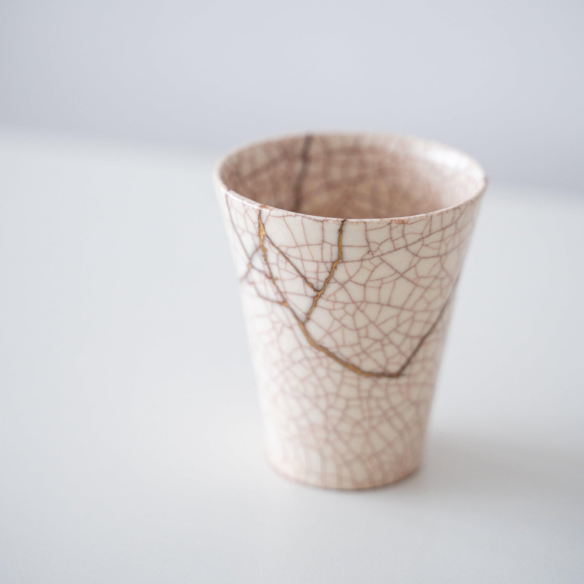 Close-up of Kintsugi Cup "Vermilion Crackle" 02 side, highlighting the intricate Kintsugi repairs