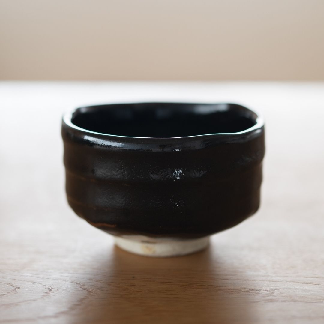 Substantial, handcrafted Japanese matcha bowl with black glaze and wabi sabi inspired texture.