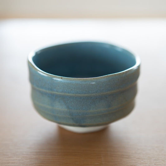 Full side view of the "Summer Sky" Japanese matcha bowl, showcasing the rich, textured blue glaze, distinctive horizontal ridges, and its traditional Mino Ware form.
