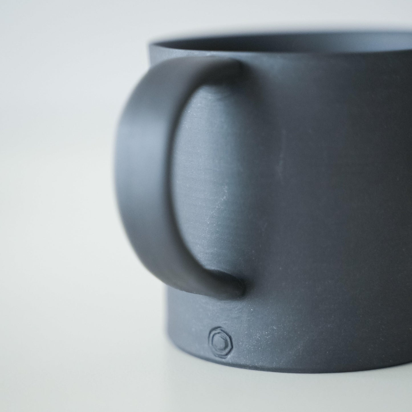 The handle of a simple black Banko ware mug.