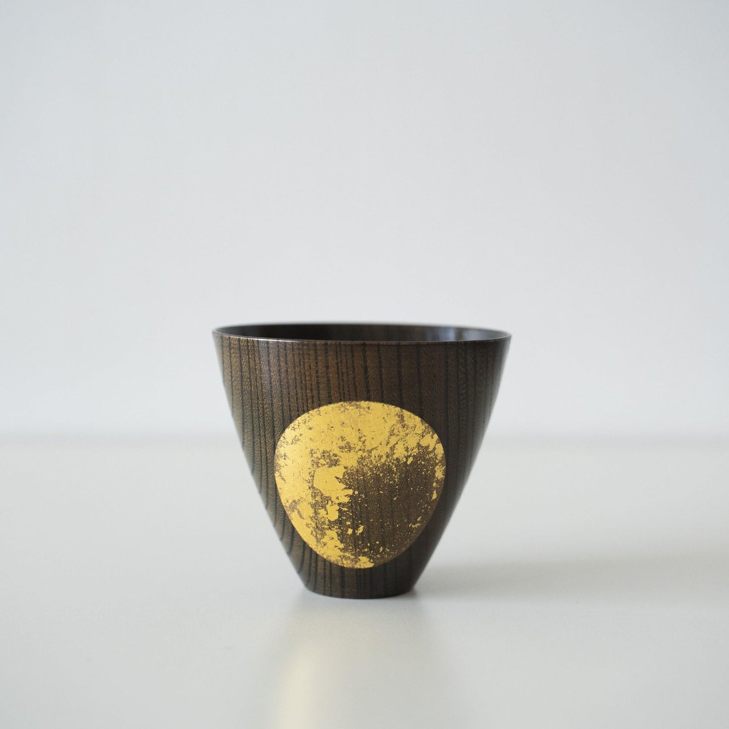 A Japanese Gold Leaf Sake Cup on a white table