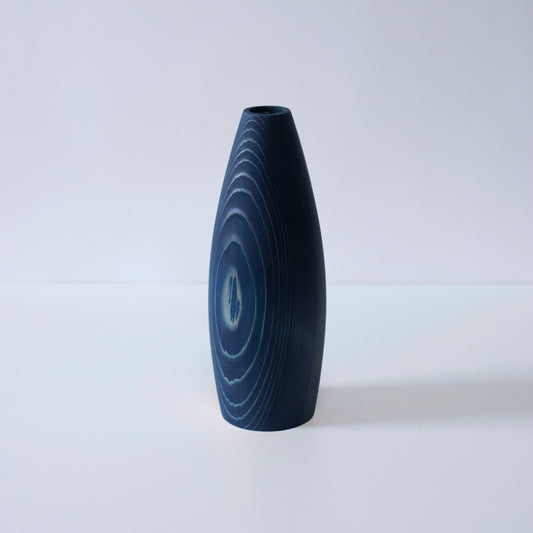 A minimalist, indigo-dyed cedar wood vase, showcasing the beauty of natural materials and Japanese craftsmanship.