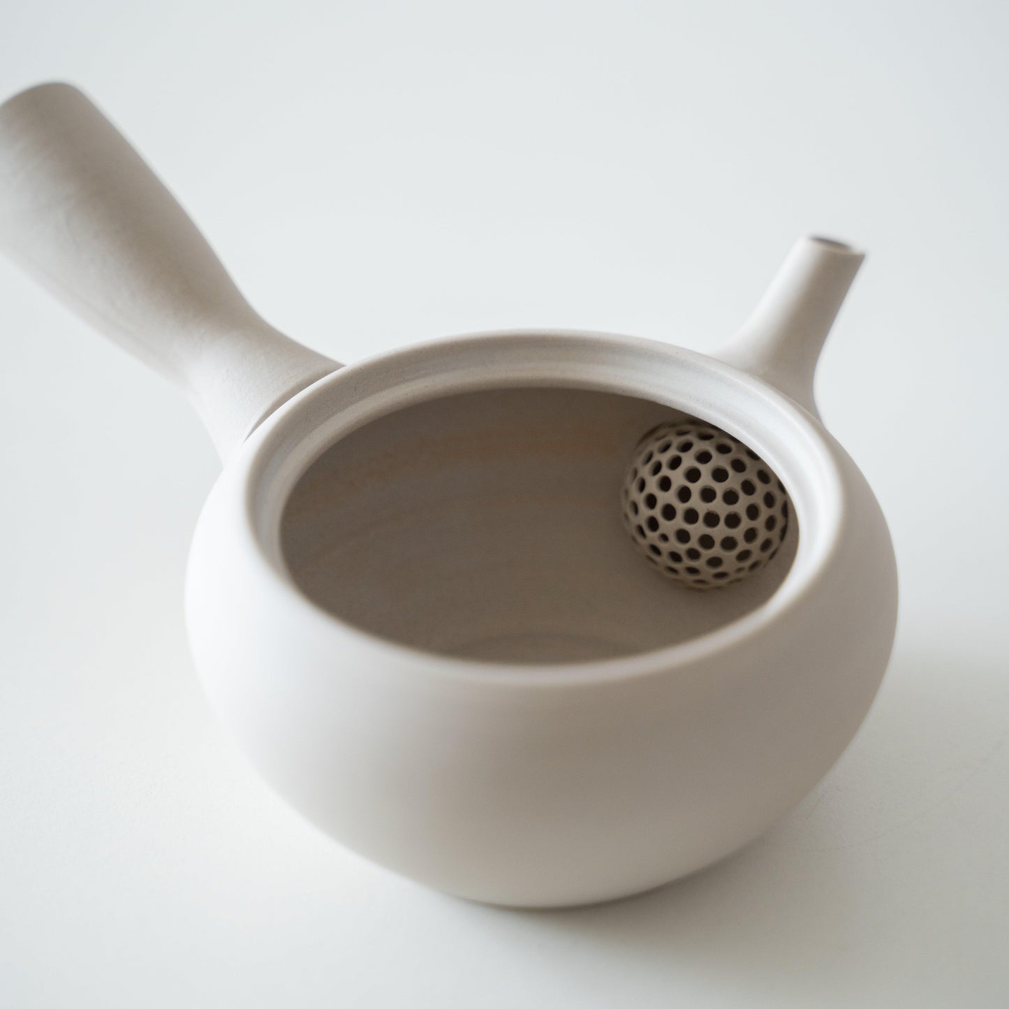 Inside a simple and soft-shaped white Banko ware teapot.