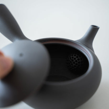 A Japanese black teapot on a white table