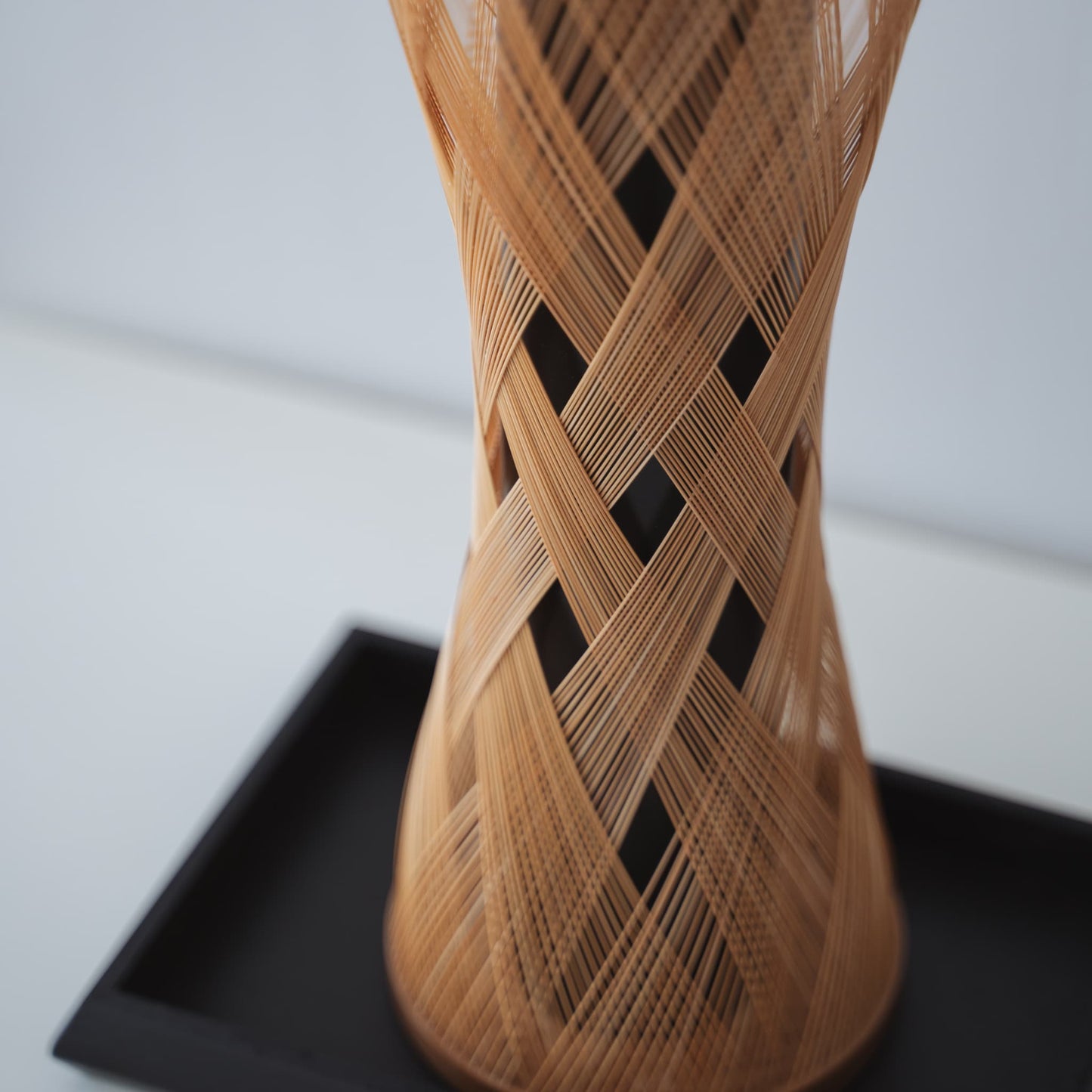 A Japanese bamboo vase on a white table