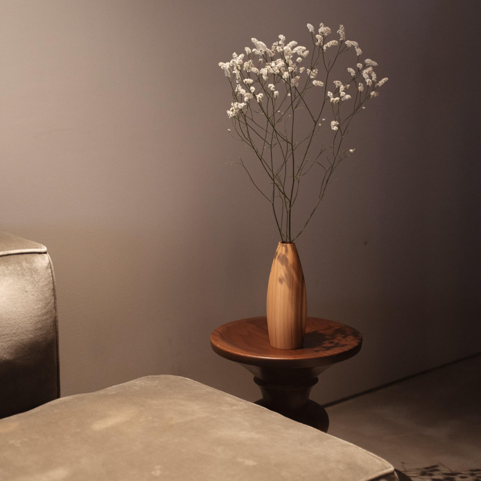 A stunning indigo-dyed cedar vase adds a touch of nature to a minimalist Japandi living room.