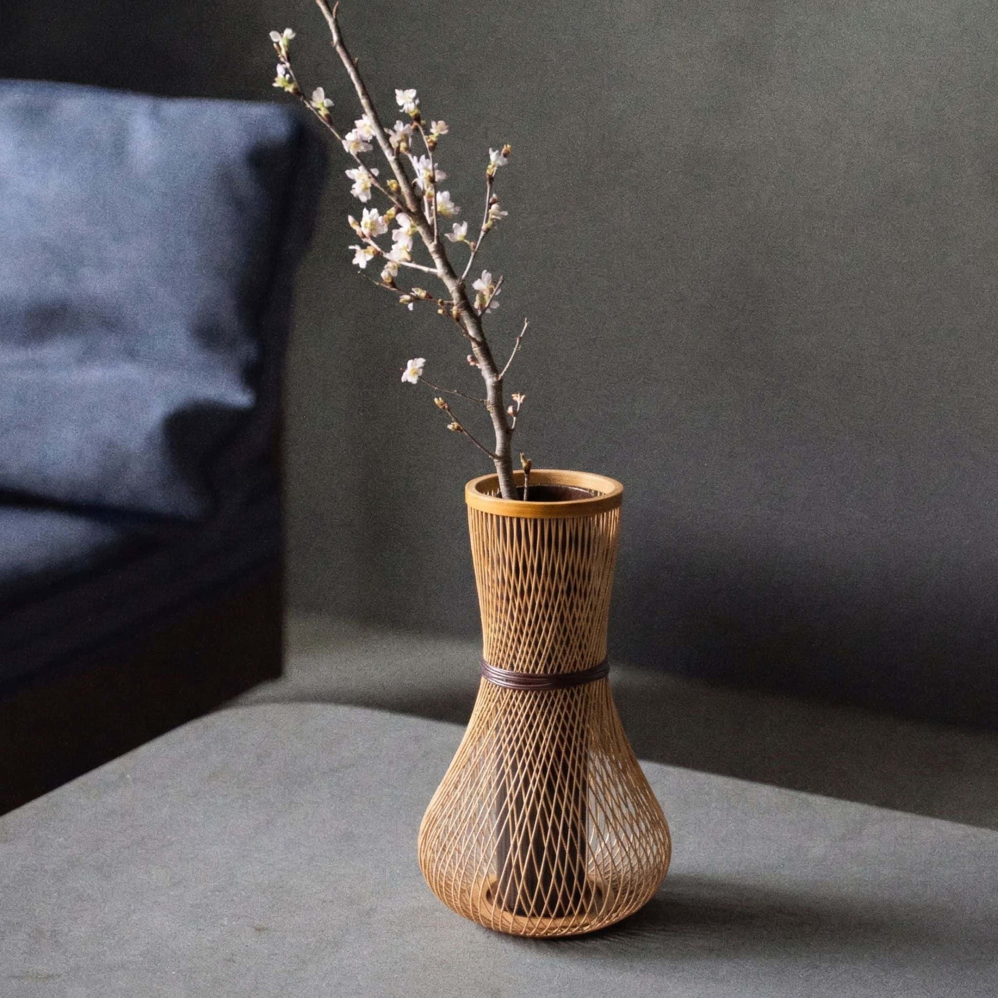 Japanese bamboo vase titled "Fukuju" displayed on a gray hotel table.