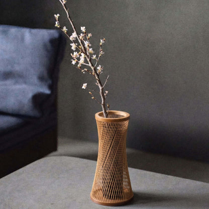 Japanese bamboo vase titled "Kanon" displayed on a gray hotel table.