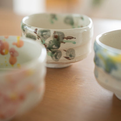 The "Forest" matcha bowl displayed in a setting that highlights its organic form and Wabi Sabi aesthetic, handcrafted by Shinzan Kiln artisans in Gifu.
