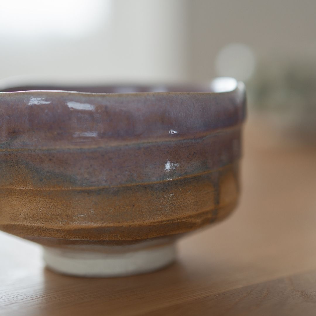 Handcrafted Japanese matcha chawan bowl with pale violet and earthen Shino glaze, embodying the wabi sabi aesthetic.