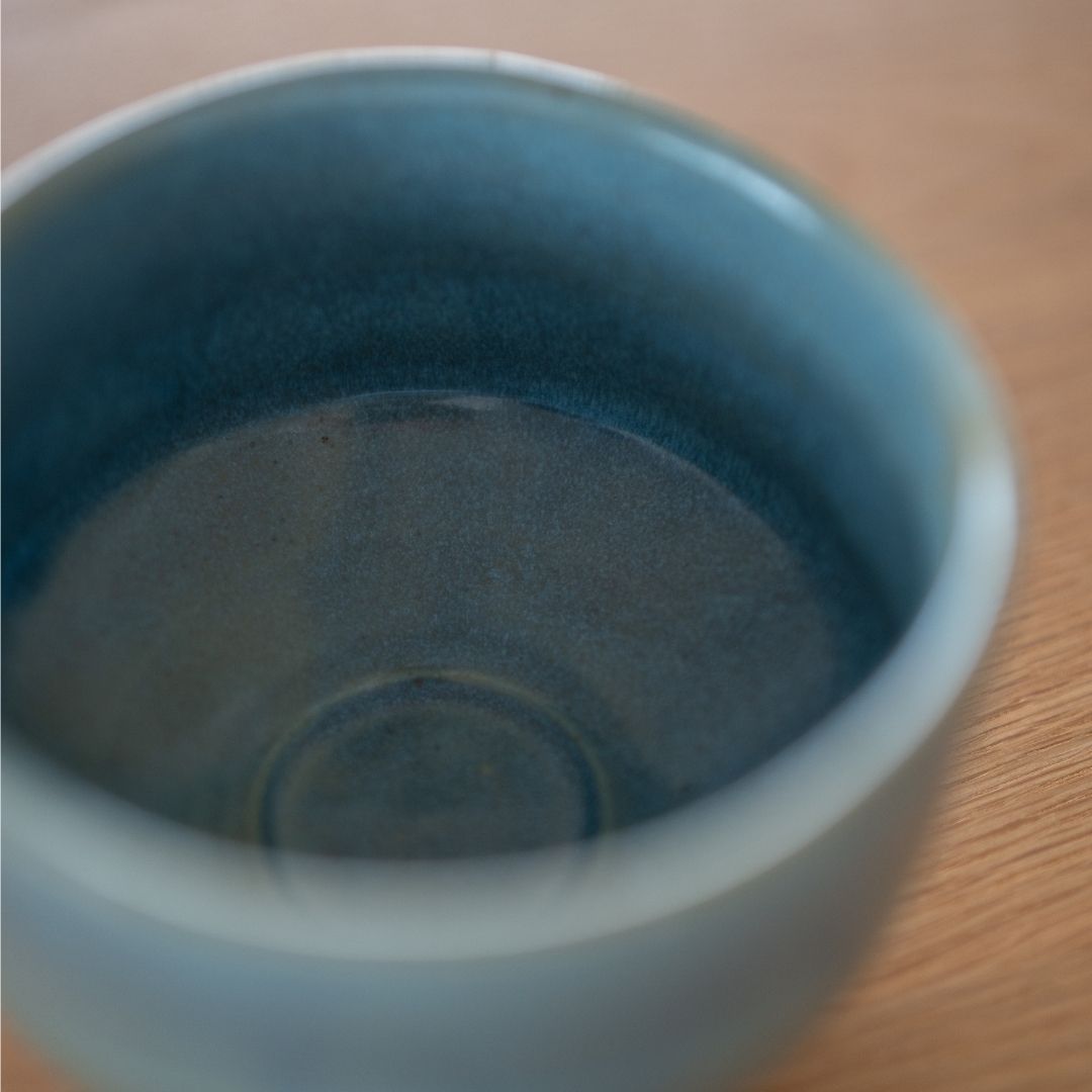 Close-up view of the deep, textured blue glaze inside the handcrafted "Summer Sky" Japanese matcha bowl, highlighting the Mino Ware's vibrant color and wabi sabi aesthetic.