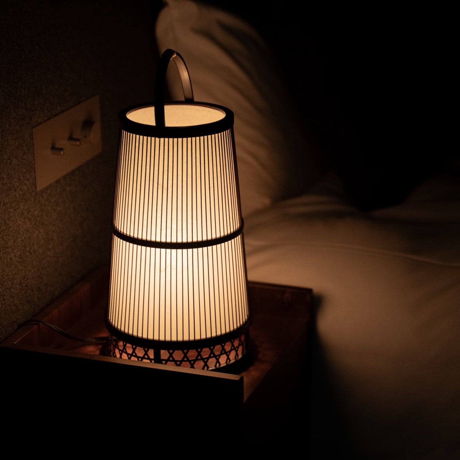 Japanese Bamboo Floor Lamp "Hagoromo" on a bedside table