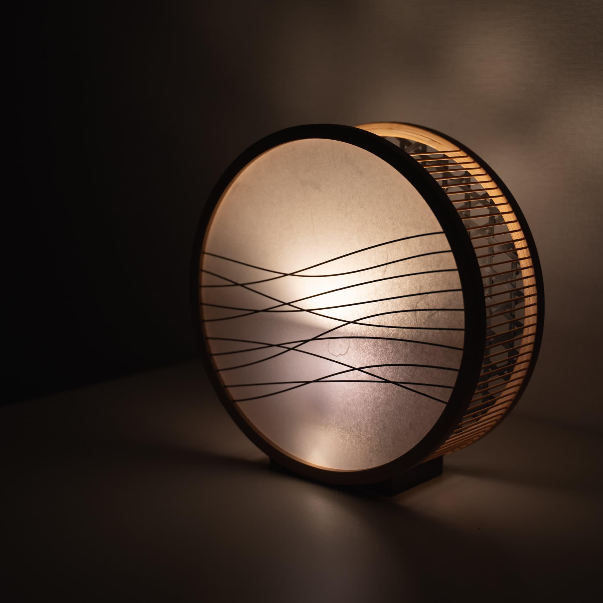 Traditional Japanese bamboo lamp handcrafted in Shizuoka with 800-year-old techniques. Circular wooden frame with washi paper shade featuring delicate bamboo accents. 