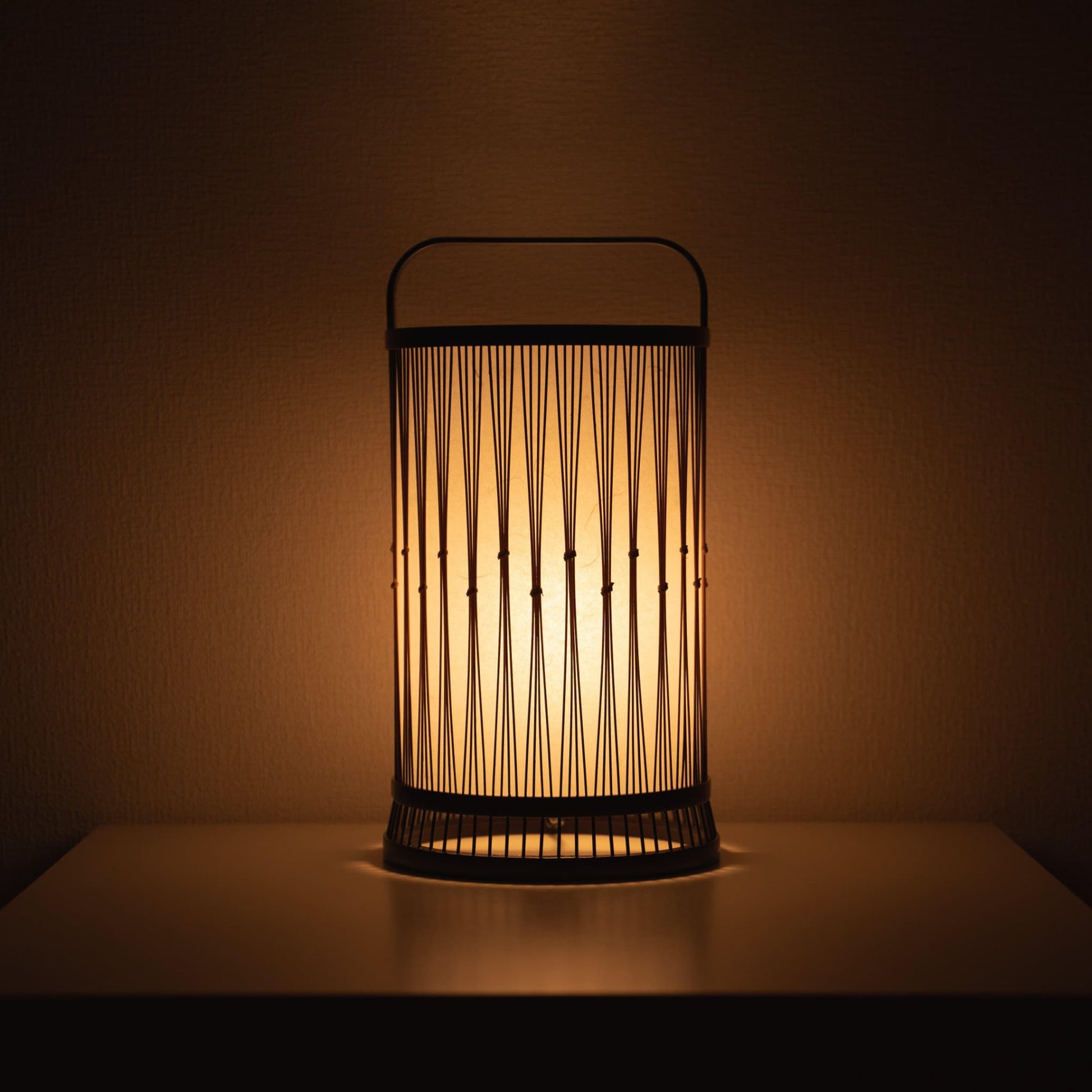 Japanese lamp crafted with 800-year-old Shizuoka bamboo artistry. Delicate bamboo strips create intricate patterns, casting a warm glow through Japanese paper.