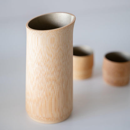 Luxurious Japanese sake pitcher, meticulously handcrafted by Kyoto artisans over 10 years using natural bamboo, showcasing the exquisite craftsmanship and the serene beauty of Kyoto's bamboo forests.