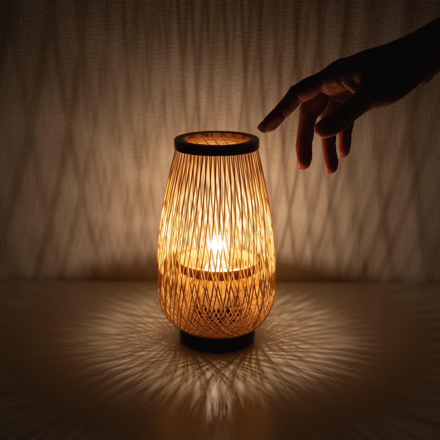 A Japanese bamboo table lamp with a hand