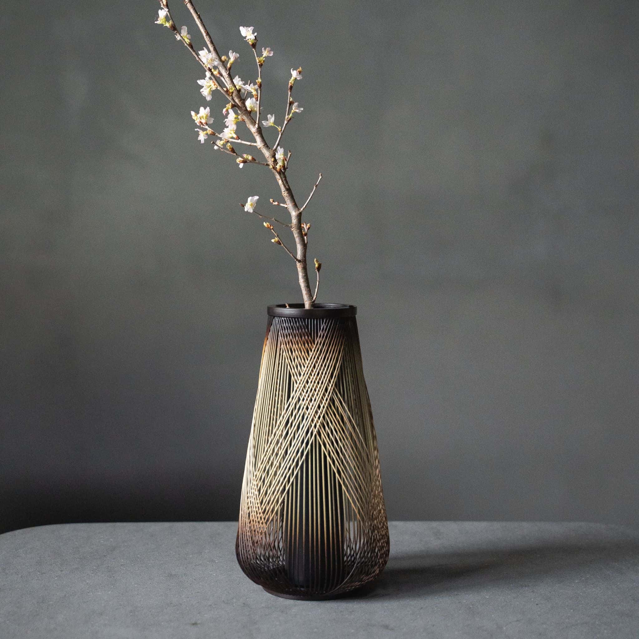 Japanese bamboo vase titled "Rising Dragon" displayed on a gray hotel table.