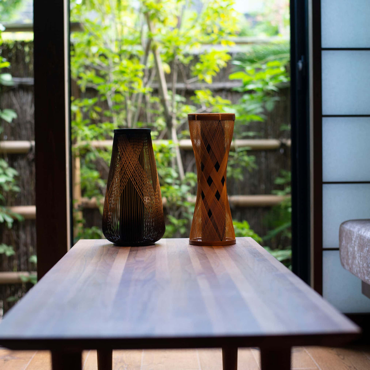 Two Japanese bamboo vases on a wooden table in Japandi living room. 