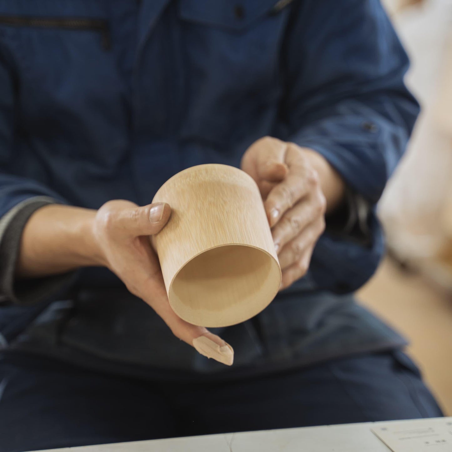 A hand holding a cup made from Japanese bamboo