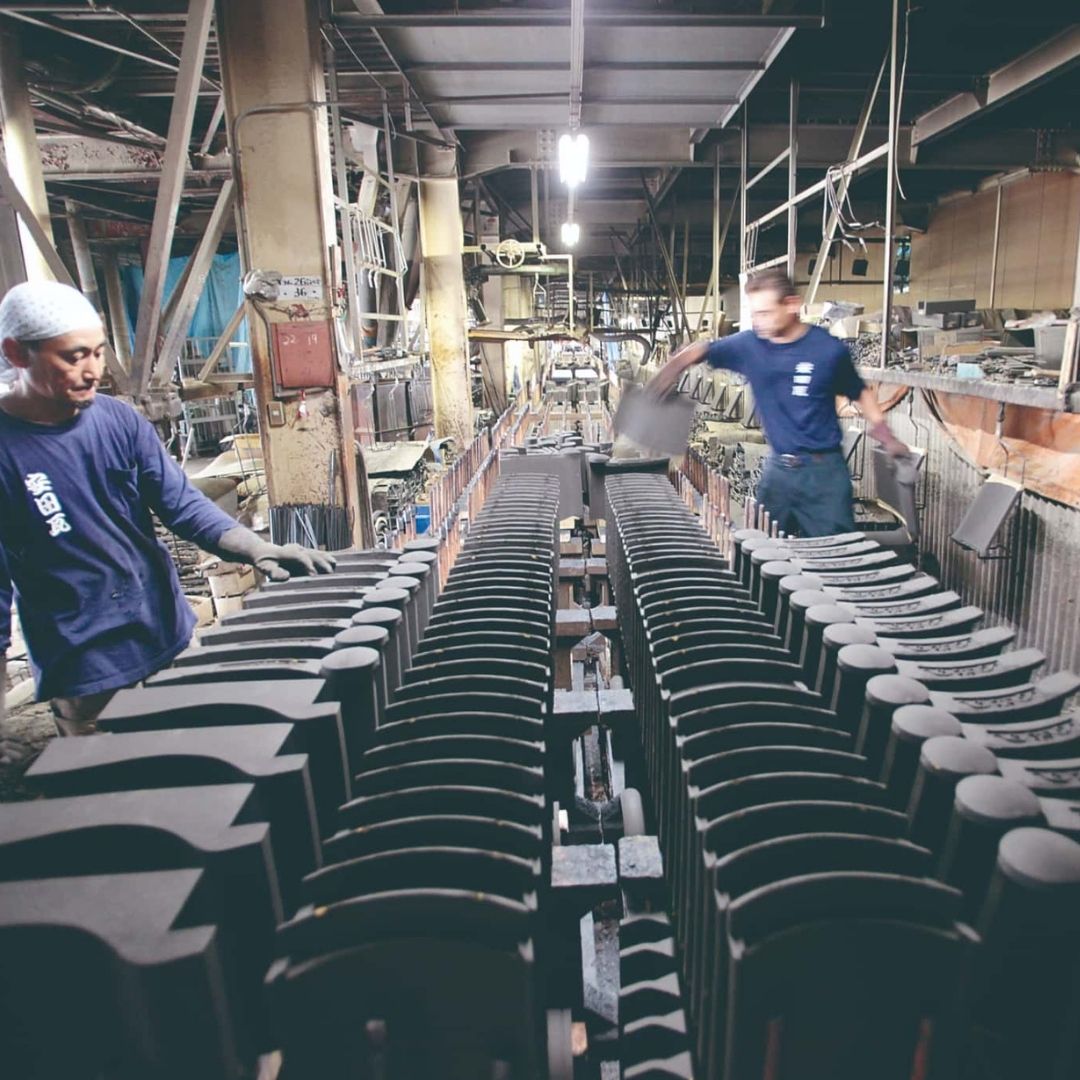 Yasuda roof tiles are inspected by two craftsmen in a factory