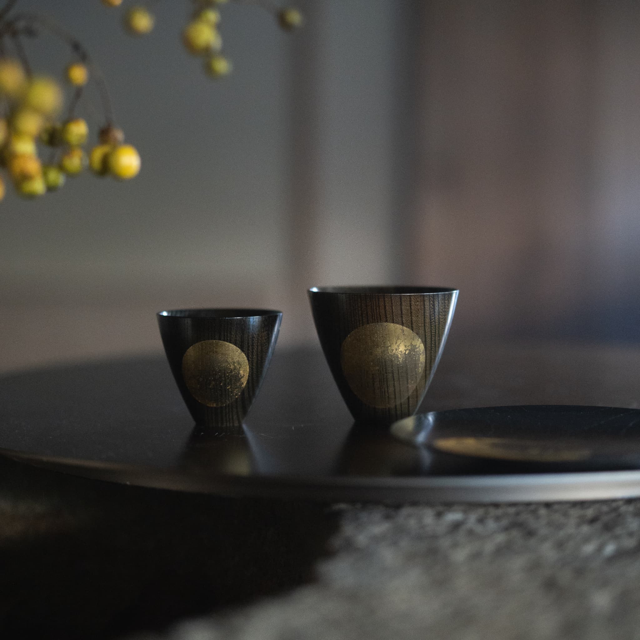 Sake cups and a Japanese plate on a wooden table