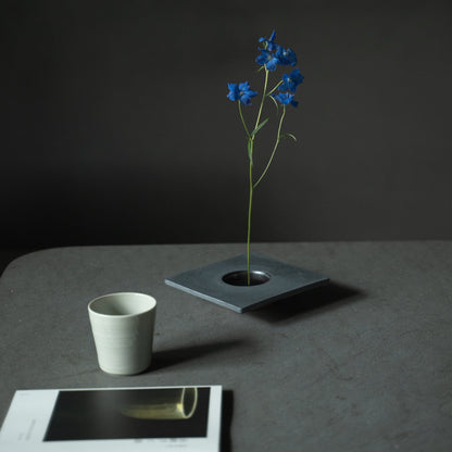 Close-up of a Japanese iron ikebana vase, showcasing the kenzan (flower frog) for arranging flowers.