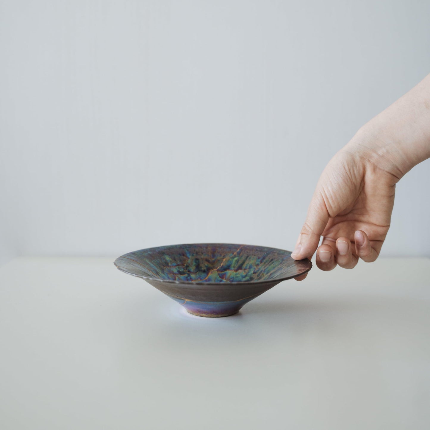 Iridescent bowl repaired with Kintsugi, a traditional Japanese technique that embraces the beauty of imperfection.