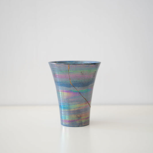 Japanese Kintsugi cup in a mercury-like blue color, showcasing the beauty of imperfection.