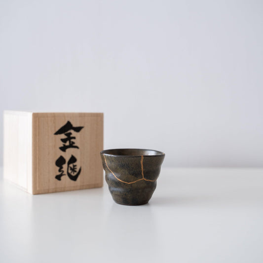 Gift set of a deep green sake cup repaired with Kintsugi, a traditional Japanese technique, and a paulownia wood box.